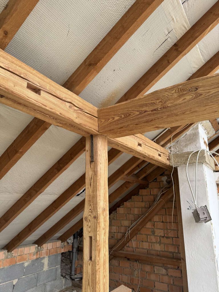 Holzbalken waehrend der sanierung mit eisstrahlen in einem gebaeude.